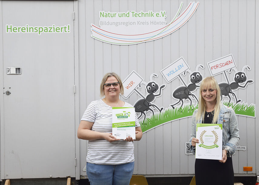 Anja Klatt und Sarah Mönnekes halten 2 Urkunden der Re-Zertifizierung in den Händen.
