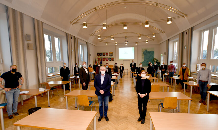 21 Personen des Kulturbeirats des Kreises Höxter stehen in der Aula des Kreishauses.