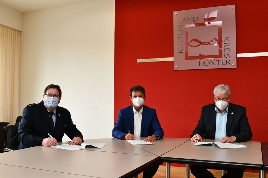Christian Brenski, Landrat Michael Stickeln und Klaus Brune unterschreiben an einem Tisch die Kooperationsvereinbarung
